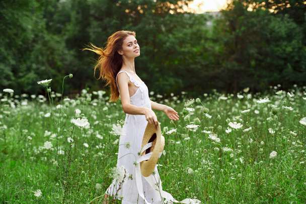 cheerful woman in a field outdoors flowers fresh air freedom - Фото, изображение