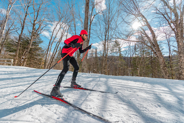 Cross Country Skate Skiing Style - Man on Nordic Ski in Forest in winter doing fun endurance winter sport activity in the snow on cross country ski in beautiful nature landscape - Foto, afbeelding