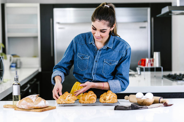 young Latin woman baking croissant ingredients in kitchen in Mexico Latin America - Foto, Imagem