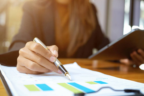 Imagem de close-up da mulher de negócios apontando caneta na papelada relatório financeiro na mesa. - Foto, Imagem