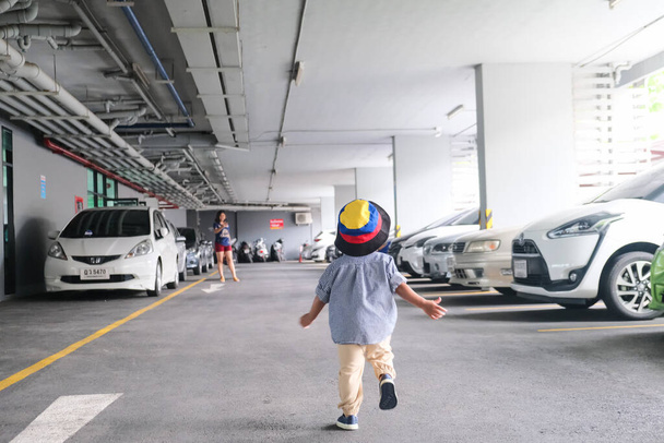Kleiner Junge, der auf dem Parkplatz spaziert, trägt Sommerurlaubstoff bereit für die Reise - Foto, Bild