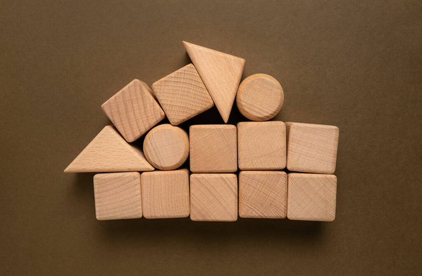 Дерев'яні геометричні фігури Куб на фоні паперу, Це може бути використано для минулих слів
 - Фото, зображення