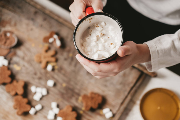 a cup of cocoa with marshmallows close-up, against the backdrop of Christmas cookies. Christmas sweets with cocoa and marshmallows for children on a wooden background. Winter vacation at home. - Fotó, kép
