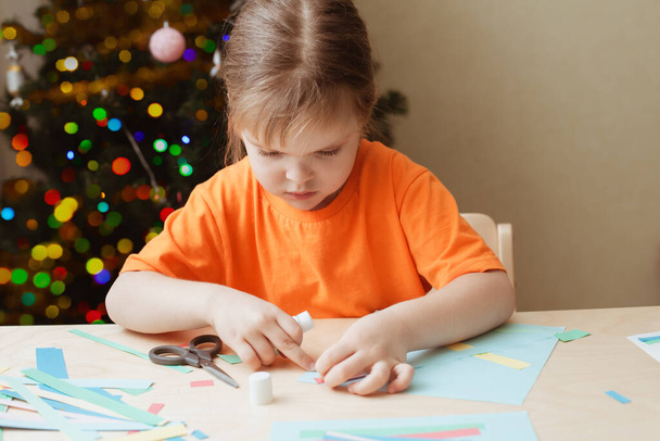 Little Girl Making Christmas Card sitting by table - Zdjęcie, obraz