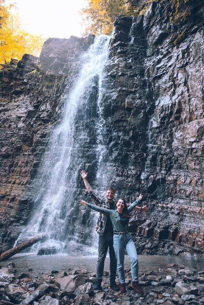 couple in front of waterfall autumn season copy space - Photo, Image