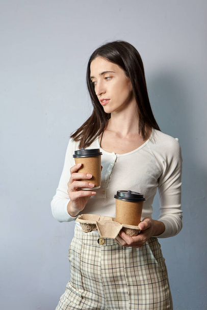 A woman holds two cups of coffee - Photo, Image