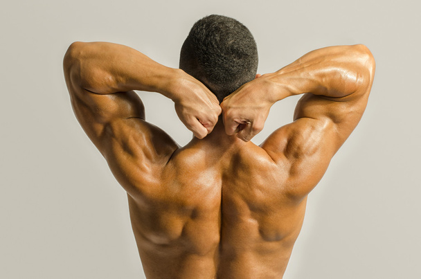 Bodybuilder showing his back,shoulders, triceps and biceps muscles, personal fitness trainer - Foto, afbeelding