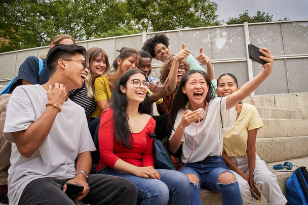 Gruppo di studenti multirazziali scattare selfie con il telefono cellulare. Compagni di classe insieme divertirsi. - Foto, immagini