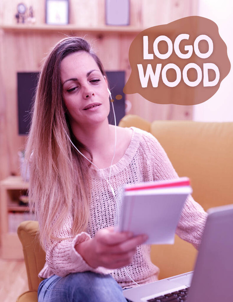 Tekstimerkki, jossa näkyy Logo Wood. Liiketoiminta konsepti Tunnustettava muotoilu tai symboli yrityksen kirjoitettu puuhun selaaminen ja jutteleminen sosiaalisessa mediassa, etsiminen ja katselu Videot - Valokuva, kuva