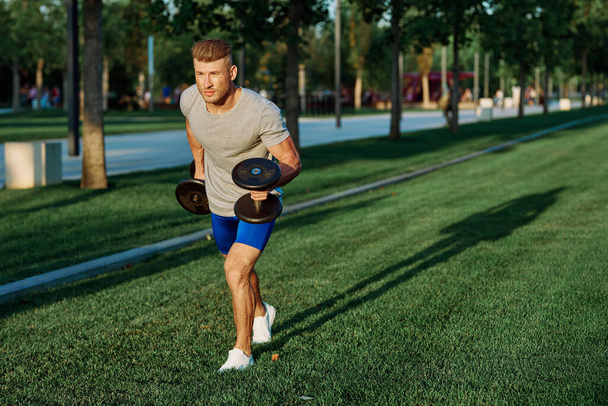 male athlete park with dumbbells doing CrossFit exercise - Foto, immagini