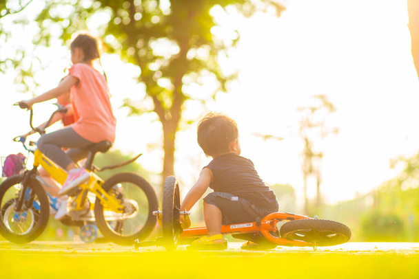 Little boy ride balance bike on road in city public tree park sport activity - Photo, Image