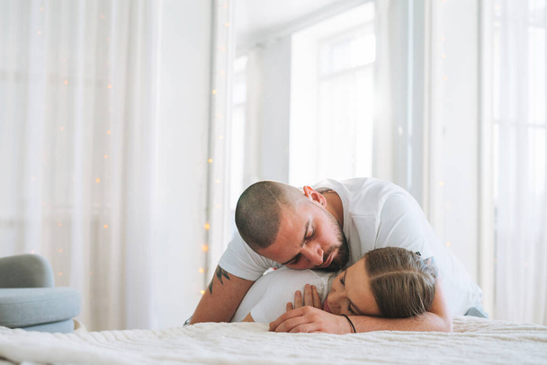 Giovane coppia felice famiglia innamorata sul divano in luminoso soggiorno a casa - Foto, immagini