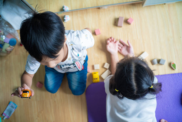 Enfants garçon et fille jouant avec un jouet en bois. Enfant en bas âge et bébé jouent avec des blocs - Photo, image