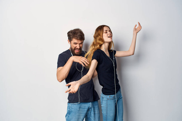 cheerful young couple in black t-shirts phone fun together friendship Studio Lifestyle - Photo, image