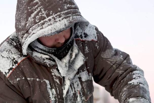 Πορτρέτο ενός πλοιάρχου σε χειμερινές φόρμες με ένα δείκτη στο χέρι του στον πίνακα πάγου - Φωτογραφία, εικόνα