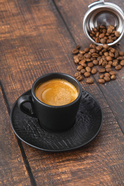 Fresh espresso coffee together decorated with coffee beans on wooden table - Фото, изображение