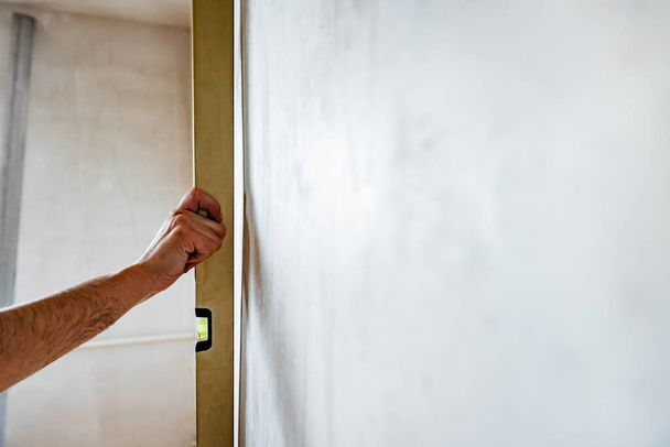 Human using spirit level to check wall level. Home renovation concept.  - Fotoğraf, Görsel
