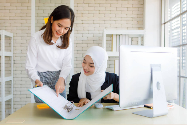 Primo piano colpo di donna d'affari asiatica presentare il suo progetto di donna musulmana di buon umore in ufficio moderno. - Foto, immagini