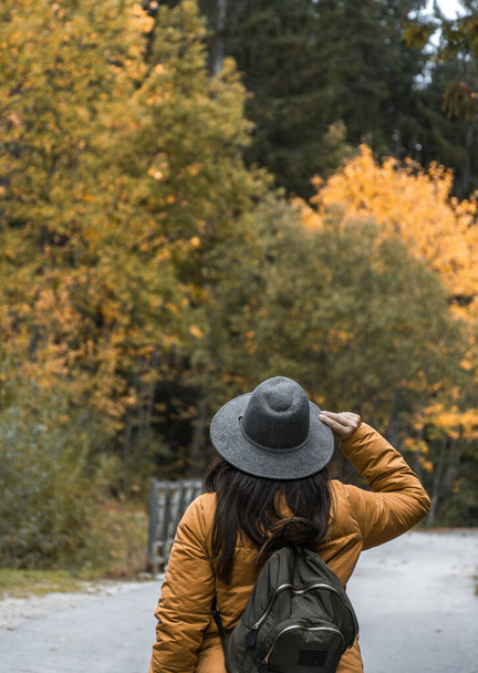 A Caucasian woman with a grey hat, and a backpack in an autumn park, Croatia - Photo, Image