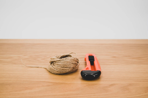 decorative cord and orange cutter on a wooden worktop with text space - Fotografie, Obrázek