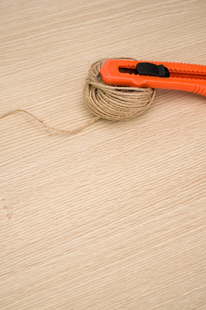 decorative cord and orange cutter on a wooden worktop with text space - Φωτογραφία, εικόνα