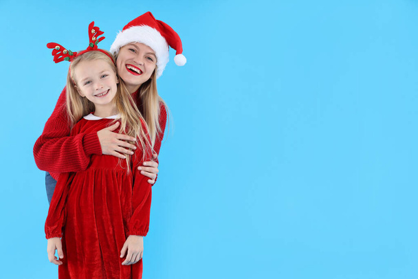 Mom and daughter on blue background, Christmas concept - Fotó, kép