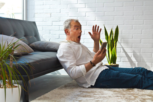 mature man with phone and surprise gesture - Photo, Image