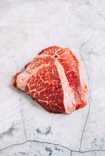 Raw fresh beef steak isolated on a table, top view. - 写真・画像