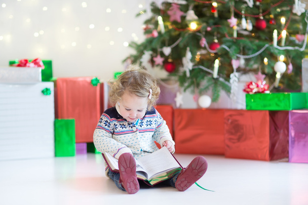 Pequena menina criança feliz com cabelo encaracolado sob a árvore de Natal
 - Foto, Imagem