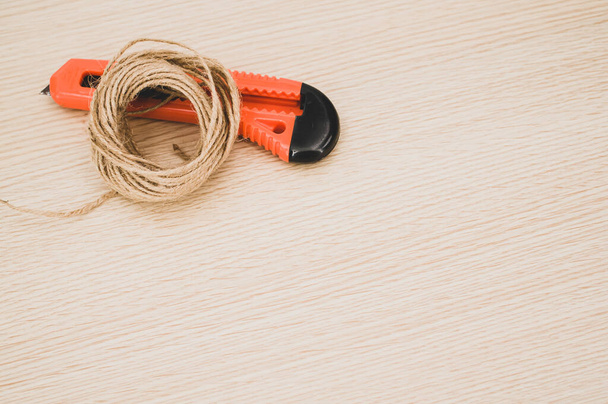 decorative cord and orange cutter on a wooden worktop with text space - Foto, afbeelding