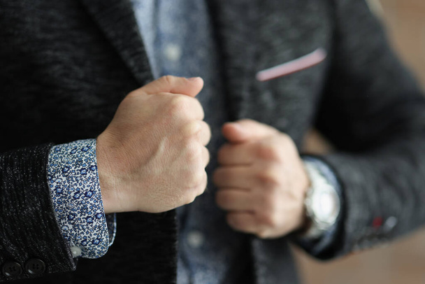 Επιχειρηματίας αγγίζει κομψό σακάκι του και να αισθάνονται σίγουροι για τον εαυτό του - Φωτογραφία, εικόνα