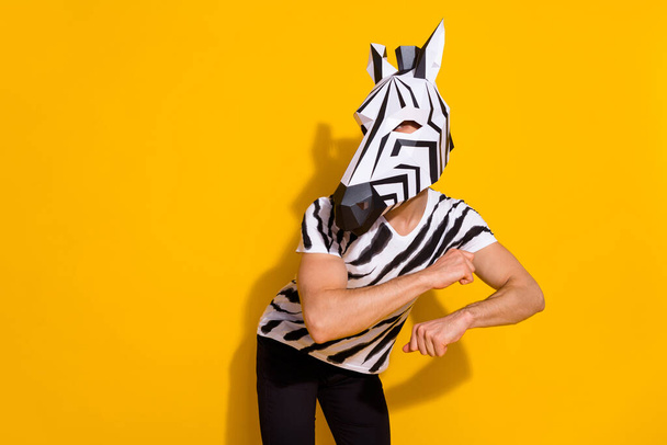 Photo of energetic weird incognito guy in zebra costume dancing isolated over bright yellow color background - Фото, изображение