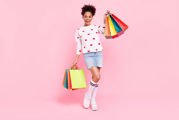 Full size photo of cool brunette millennial lady hold many packages wear sweater skirt socks shoes isolated on pink background - Φωτογραφία, εικόνα