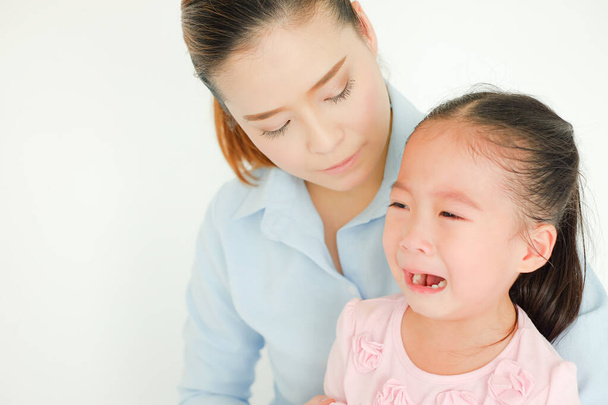 llorando asiático niña siendo consolado por solo mamá - Foto, Imagen