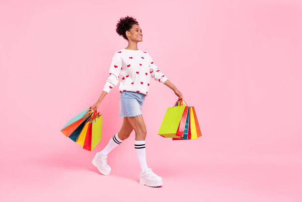 Full length profile photo of nice brunette young lady do shopping wear sweater skirt socks shoes isolated on pink background - Valokuva, kuva