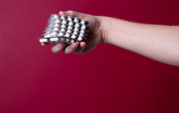 a man's hand holds a package of pills - Foto, Bild