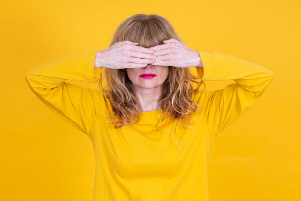 woman covering her eyes with her hands in denial - Foto, afbeelding