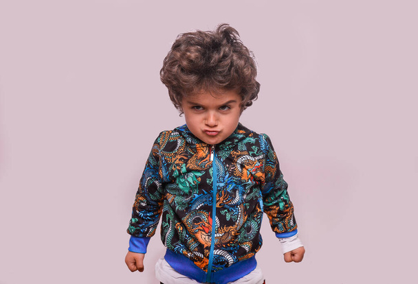 Kızgın küçük İspanyol çocuğun portresi. Yumrukları kameraya bakan stresli bir çocuk. - Fotoğraf, Görsel