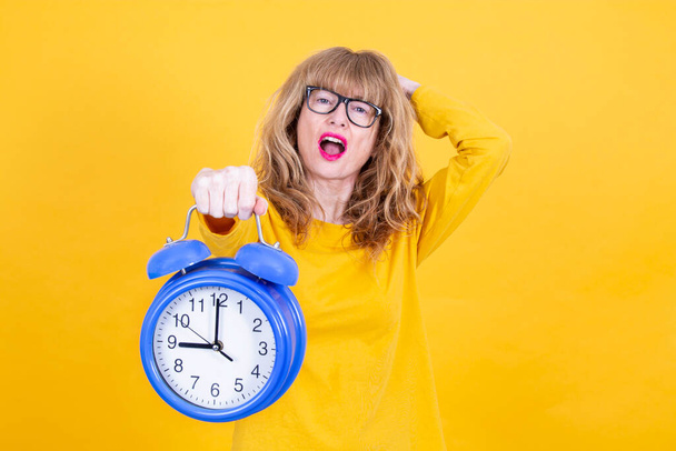nervous and worried hysterical woman with alarm clock isolated - 写真・画像