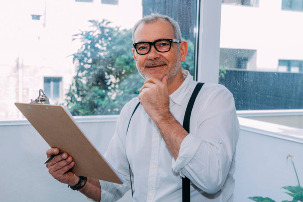 Portrait of smiling cheerful businessman in casual office reviewing documents - Fotoğraf, Görsel