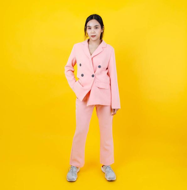 Beautiful Asian lady as fashion model of modern costume of pink jacket and pants standing with right arm akimbo expressing self-confidence. Gorgeous pastel suit for female lifestyle and cute outfit. - Photo, Image
