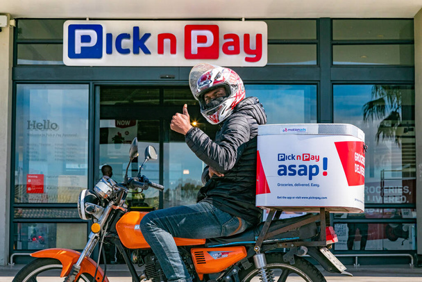 Cape Town, South Africa - September 9, 2021: Express Service delivery bikes with African rider outside local Pick n Pay grocery store - Фото, зображення