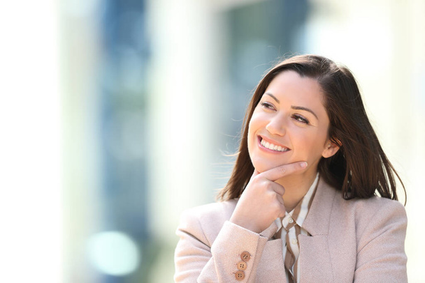 Happy businesswoman thinking looking at side outdoor in the street - Foto, imagen