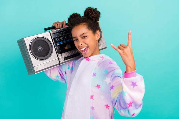 Profile side photo of young crazy black girl show horns sign rude sleepover song isolated over teal color background - 写真・画像