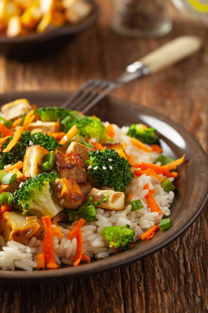 Tofu with rice and vegetables. Served on brown plate. - Photo, Image