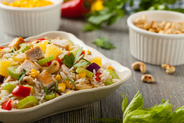 Salad with rice, chicken, peanuts and vegetables. Front view.  - Foto, afbeelding