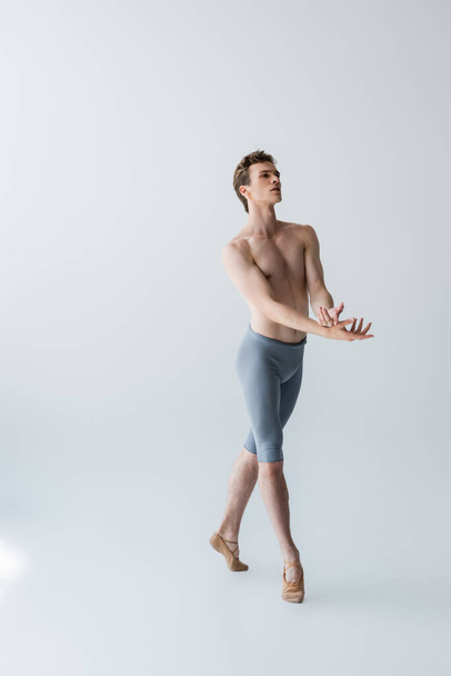 full length of graceful ballet dancer gesturing on grey - Fotoğraf, Görsel