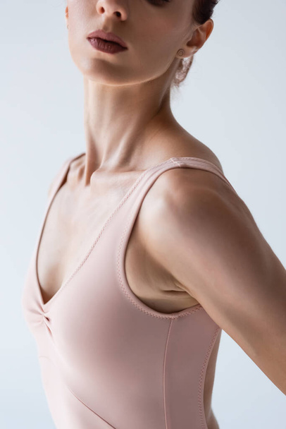 partial view of young ballerina in bodysuit isolated on gray - Foto, Imagem