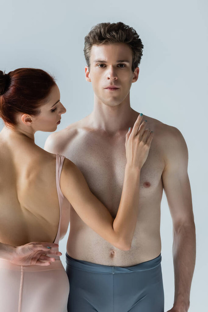 redhead ballerina near shirtless ballet dancer isolated on grey - 写真・画像