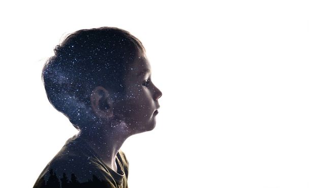 Yksittäinen yhdistelmä siluetti lapsen kasvot ja tähdet Linnunradan. Käsitys ihmisen ja maailmankaikkeuden välisestä yhteydestä, uusista löydöistä ja avaruustutkimuksesta - Valokuva, kuva